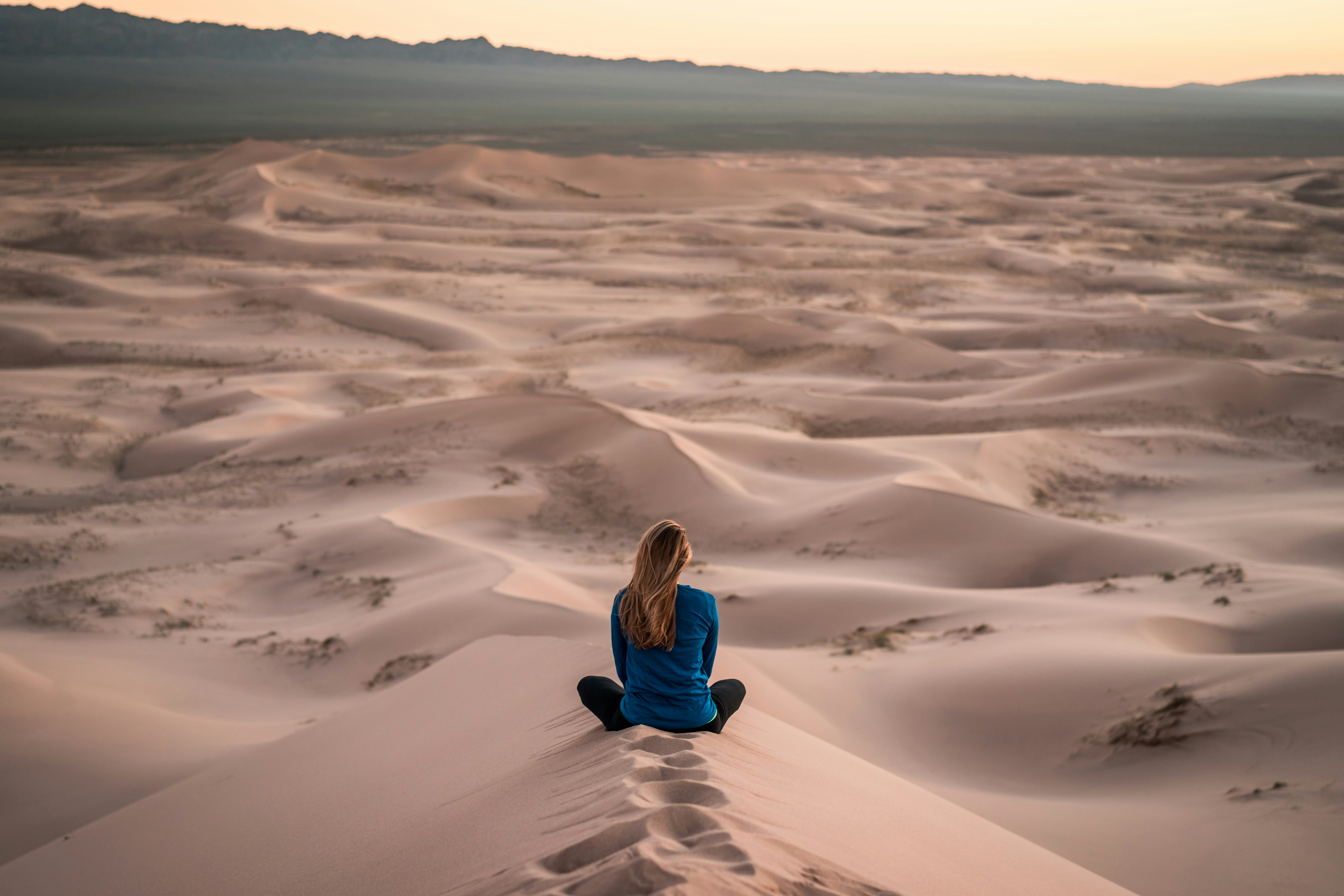 A person in quiet stillness or meditation in a calm natural setting, conveying space to think and reflect